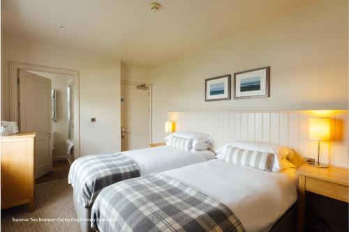 a hotel room with two beds and two lamps at St Brides Spa Hotel & Village Apartments in Saundersfoot