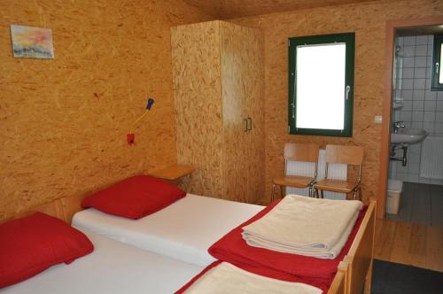 1 dormitorio con 2 camas, ventana y lavamanos en Gästedorf Waldheimat, en Langenwang