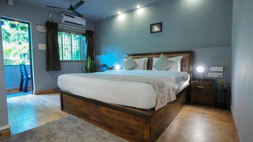 a bedroom with a large bed with white sheets at Sortby Stays, Vagator in Vagator