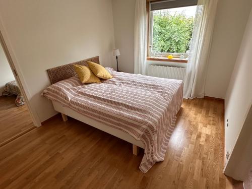 a bedroom with a bed with two yellow pillows on it at Ellös Holiday apartment in Ellös
