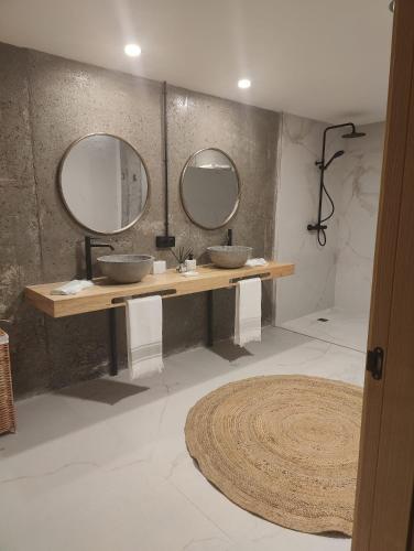 a bathroom with two sinks and two mirrors at Herminia Fariña cerca Sanxenxo in Meaño