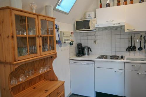 une cuisine avec des placards blancs et un comptoir blanc dans l'établissement Dike House Affordable 6-Person Holiday Home Near the Sea Dike, à Anjum
