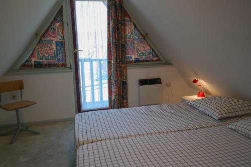 une chambre avec deux lits et une grande fenêtre dans l'établissement Dike House Affordable 6-Person Holiday Home Near the Sea Dike, à Anjum