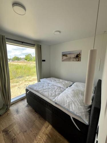 ein Schlafzimmer mit einem Bett in einem Zimmer mit einem Fenster in der Unterkunft Ferienhaus Flora in Altefähr