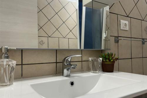 a bathroom sink with a mirror and a white sink at Rapallo-Portofino, Elegant & Comfortable House in Rapallo