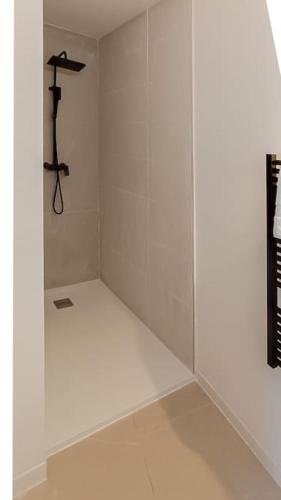 Cette chambre blanche dispose d'une cabine de douche avec un cintre. dans l'établissement Aura Plage Appartement Sunrise, à Roquebrune-sur Argens