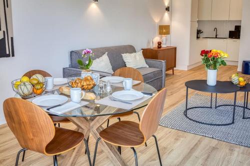 un salon avec une table en verre et des chaises dans l'établissement Aura Plage Appartement Sunrise, à Roquebrune-sur Argens