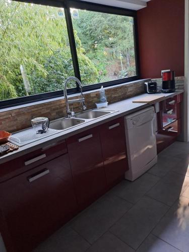 une cuisine avec un évier et une grande fenêtre dans l'établissement Maison à la campagne, à Meillac