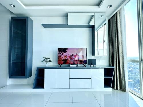 a white living room with a tv on a counter at Sophisticated 2BR Surabaya Apartment at Via Tower Ciputra World by Le Ciel Hospitality in Surabaya
