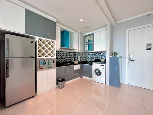 a kitchen with a refrigerator and a washer and dryer at Sophisticated 2BR Surabaya Apartment at Via Tower Ciputra World by Le Ciel Hospitality in Surabaya