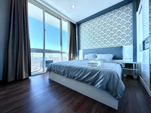 a bedroom with a bed and a large window at Sophisticated 2BR Surabaya Apartment at Via Tower Ciputra World by Le Ciel Hospitality in Surabaya