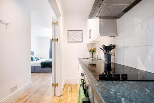 a kitchen with white walls and a counter top at Welcome London - Short's Gardens in London