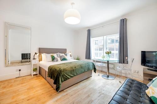 a bedroom with a bed and a flat screen tv at Welcome London - Short's Gardens in London