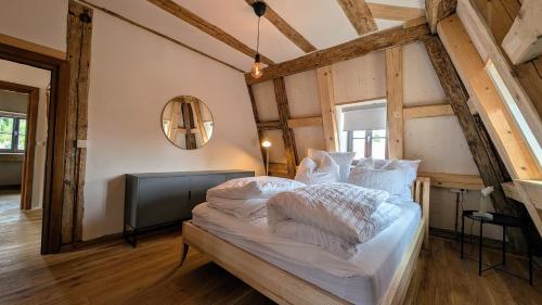 een slaapkamer met een bed met witte lakens en een spiegel bij Altes Zollhaus - Central - Lovely - Luxury - Maisonette Apartment in Schwabach