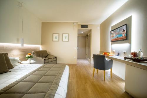 a room with a bed and a kitchen and a living room at Guesia Village Hotel e Spa in Foligno