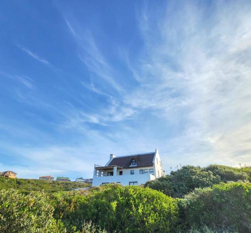 a white house on top of a hill at Kleinbos Beach Villa in Boggomsbaai