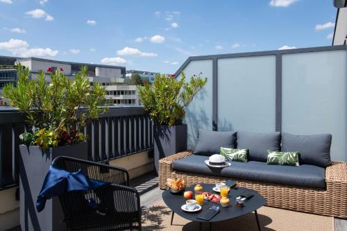 a patio with a couch and a table on a balcony at Mercure Paris Bercy Bibliothèque in Paris