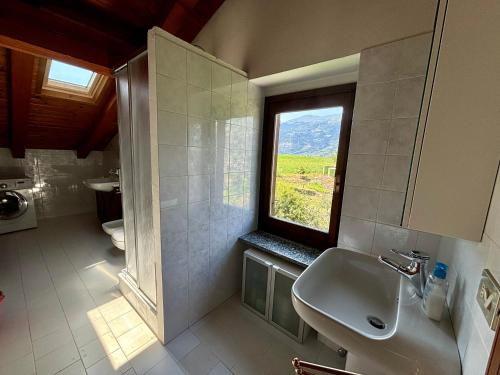 a bathroom with a sink and a window at La Casa Dell'Acero in Aymavilles