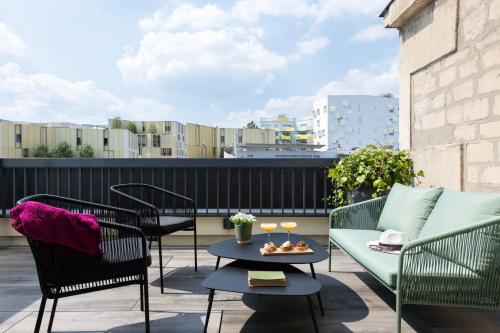 a patio with chairs and a couch and a table at Mercure Paris Bercy Bibliothèque in Paris