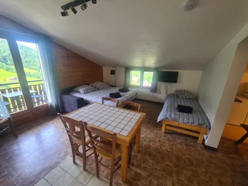 una habitación con una cama y una mesa en una habitación en La Loulettaz, en Le Grand-Bornand
