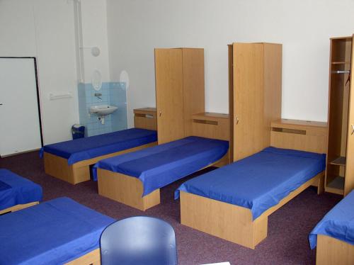 a room with three bunk beds with blue sheets at penzion FIT in Velké Losiny
