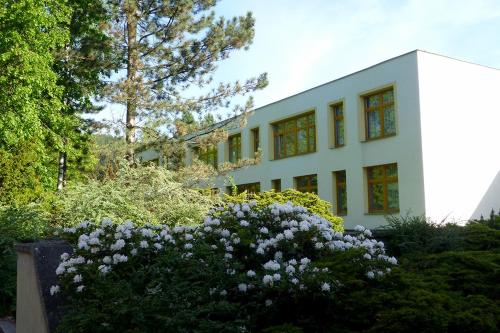 a white building with some flowers in front of it at penzion FIT in Velké Losiny