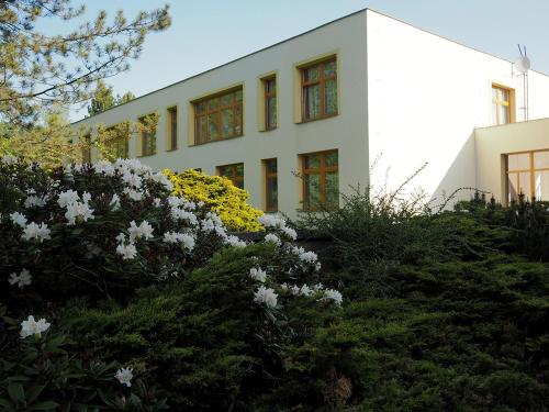 a white building with flowers in front of it at penzion FIT in Velké Losiny