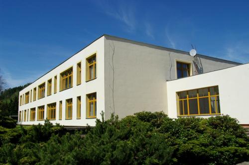 a white building with yellow windows on the side of it at penzion FIT in Velké Losiny