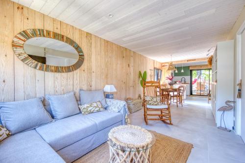 un salon avec un canapé bleu et un miroir dans l'établissement Maison de charme au bord du lac, à Hourtin