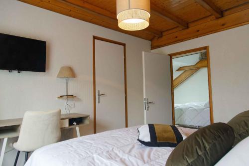 a bedroom with a bed and a desk and a mirror at Maison Capdet in Fresse-sur-Moselle