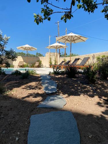 a walkway with umbrellas and a pool at Aoni Suites in Aegina Town