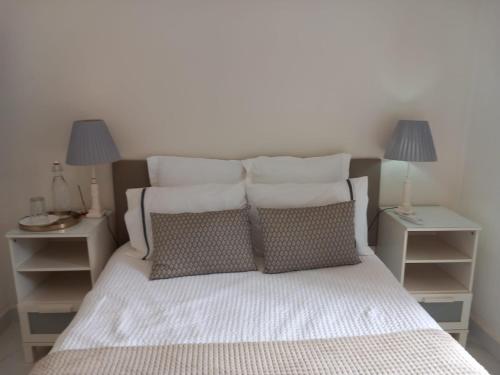 a bedroom with a bed with pillows and two lamps at White Star Estoril in Estoril