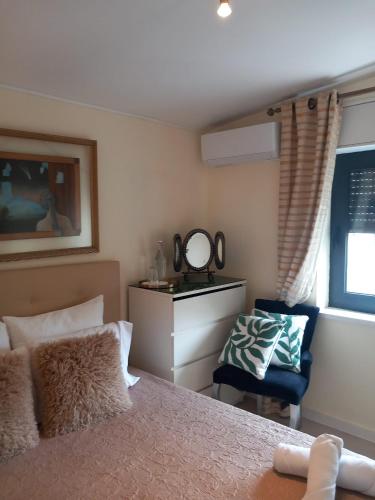 a bedroom with a bed and a chair and a mirror at White Star Estoril in Estoril
