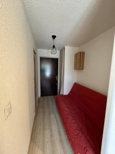 - une chambre avec un lit rouge et une porte noire dans l'établissement Chaleureux appartement moderne, à Briançon