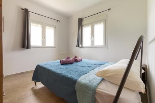 a bedroom with a bed with purple shoes on it at Countryside apartments ground floor in Gómfoi