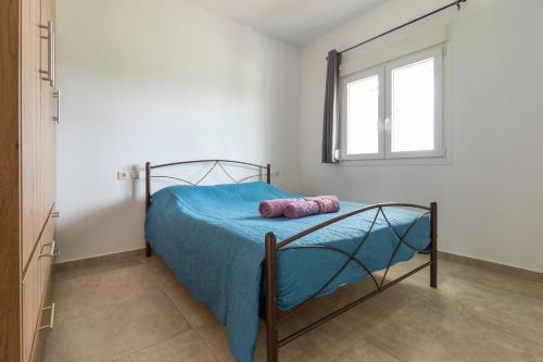 a bedroom with a bed with blue sheets and a window at Countryside apartments ground floor in Gómfoi