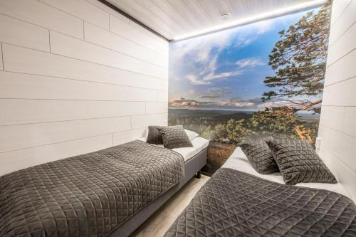 two beds in a room with a large window at Pärjä Suites 3 in Syöte