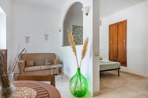 a living room with a green vase and a couch at Selva Panorama in Selva di Fasano