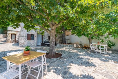 a table and chairs under a tree in a yard at Selva Panorama in Selva di Fasano