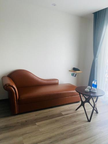 a living room with a brown couch and a table at ATOUR Phoenix Hotel in Bắc Ninh