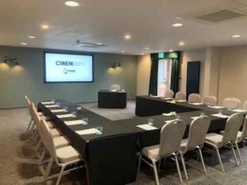 a conference room with a table and chairs and a screen at Holiday Inn Telford Ironbridge by IHG in Telford