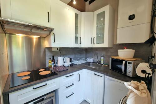 une cuisine avec des armoires blanches et un micro-ondes dans l'établissement 