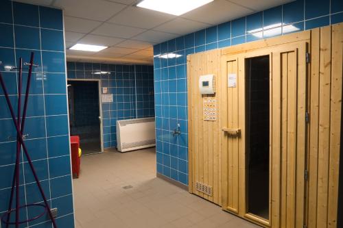 a bathroom with blue tile walls and wooden stalls at Vacancéole - Les Rives de Pont-Aven in Pont-Aven