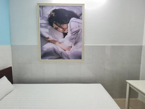 a picture of a woman sleeping on a bed at Bin Hom Motel in Bien Hoa