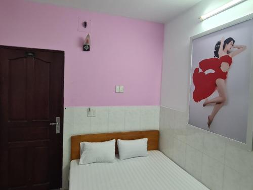 a bedroom with a picture of a woman on the wall at Bin Hom Motel in Bien Hoa