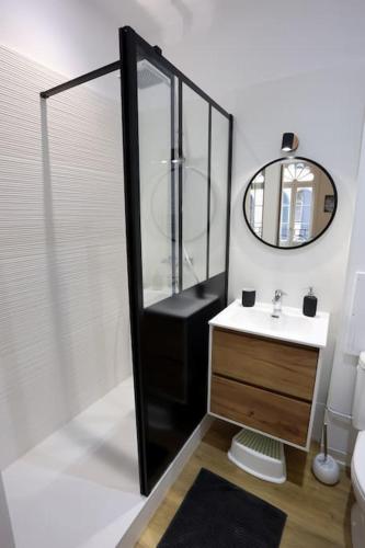 une salle de bain avec une douche, un lavabo et un miroir dans l'établissement Chez Juliette, proche Place Nationale avec parking, à Montauban