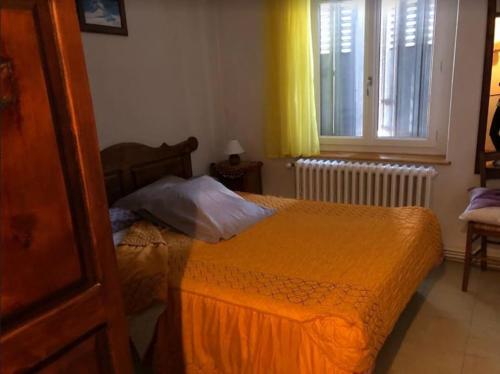 - une chambre avec un lit doté d'une couette en orange et d'une fenêtre dans l'établissement Appartement Le Ranch Vars Ste Marie, à Vars