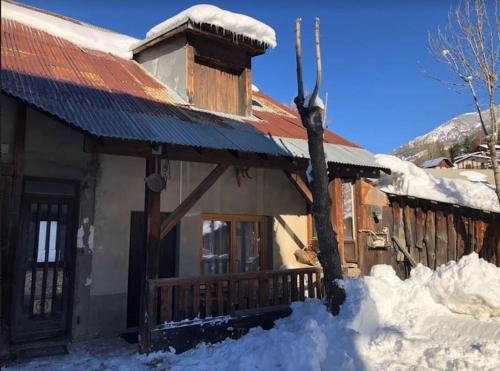 une cabane en rondins dans la neige avec de la neige autour de celle-ci dans l'établissement Appartement Le Ranch Vars Ste Marie, à Vars