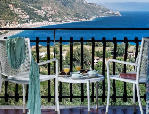 a table and chairs on a balcony with a view of the ocean at Hotel Sirius in Taormina