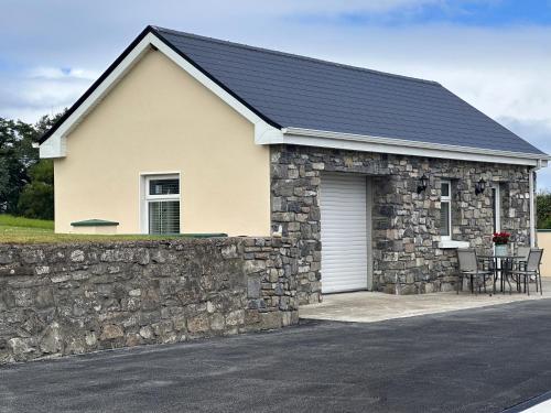 a stone house with a garage and a stone wall at The Waters Edge in Aughris